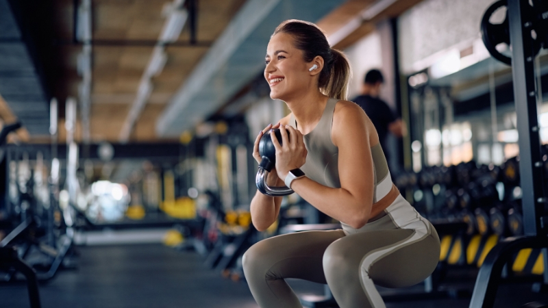 Žena radi vežbu sa tegovima u teretani kao deo treninga tokom fasting dijete
